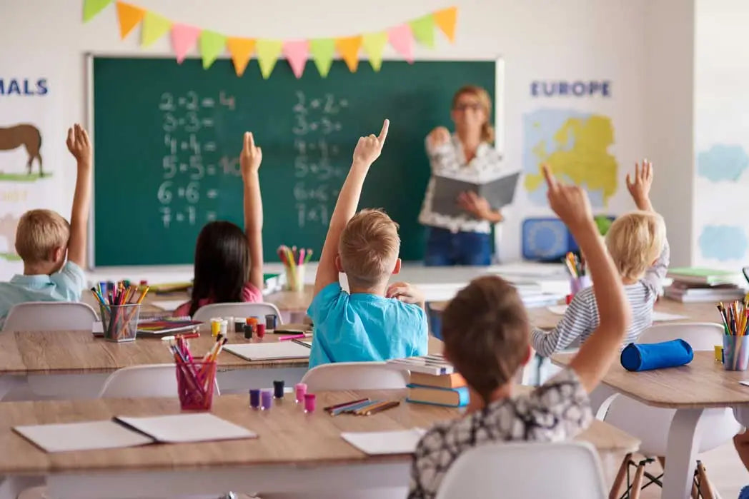 children raising hands in classroom representing kids with diabetes staying active and engaged at school Image