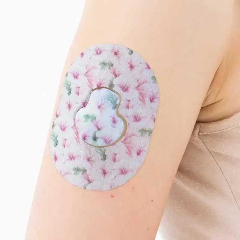 Guardian Enlite Sensor Patches worn on arm, featuring a pink and green floral design for daily use and protection. Image