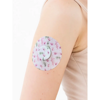 Patch adhésif FreeStyle Libre 2, série Spring, sur le bras avec sa pastille centrale décorative