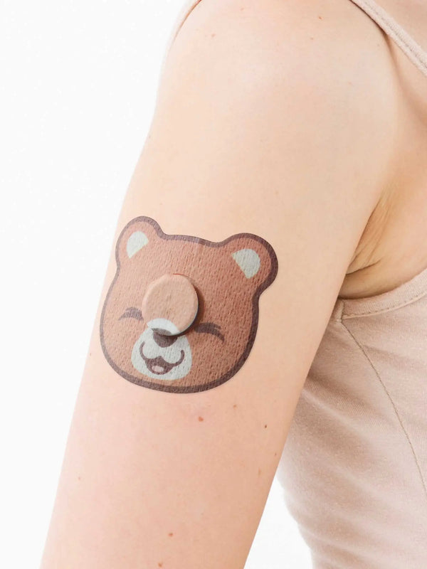 Bear-shaped kids adhesive patch for FreeStyle Libre 3 sensor worn with central sticker