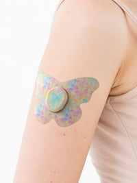 Patch adhésif Dexcom G7, forme papillon, sur le bras, gros plan