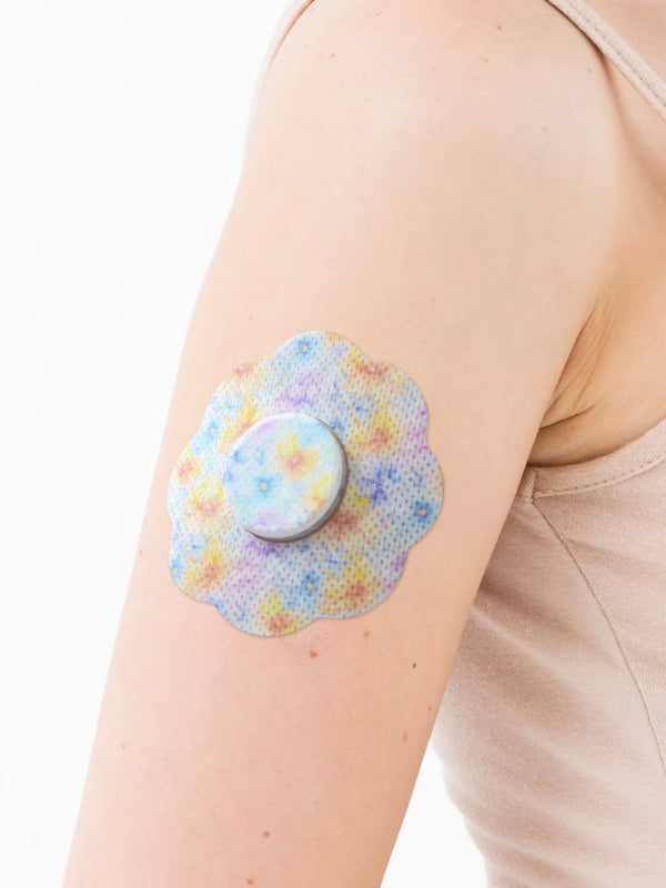 FreeStyle Libre 2 cookie shape patch close-up on arm, showing breathable adhesive support around the sensor